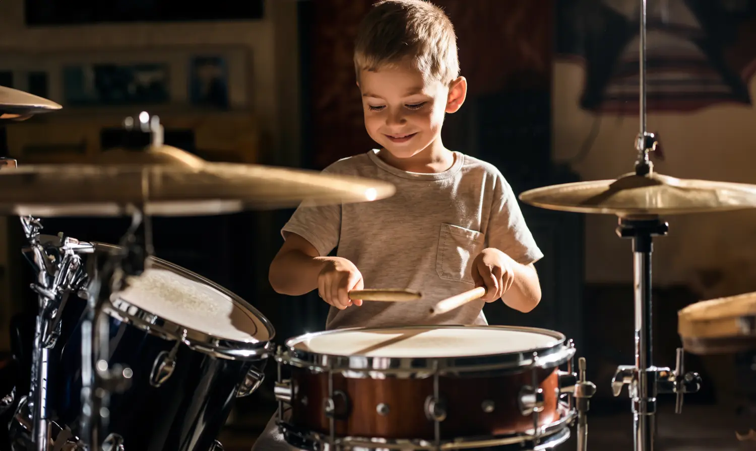Foto van een kind wat aan het drummen is